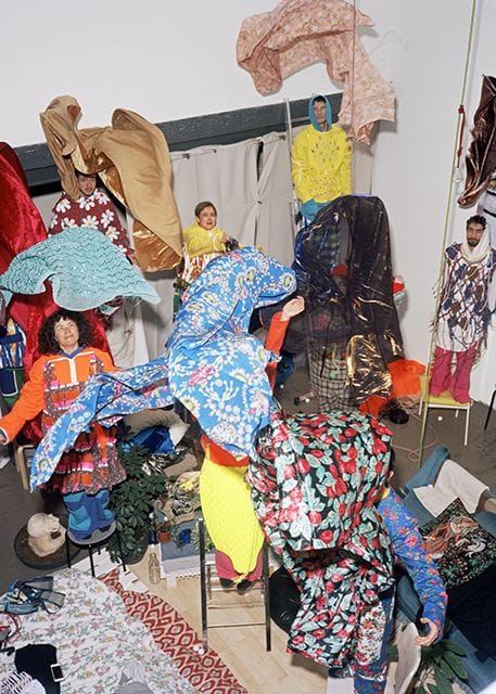 Alphée, Boris, Elisa, Henri, Irène, Jake, Masaki, Matthieu, Raphaël on chairs in the living room of Argenteuil, wearing creations by Wataru Tominaga and fabrics from the market, 2018. Digital photograph. Dimensions variable. Courtesy of the artist. Photo: Hubert Crabières.